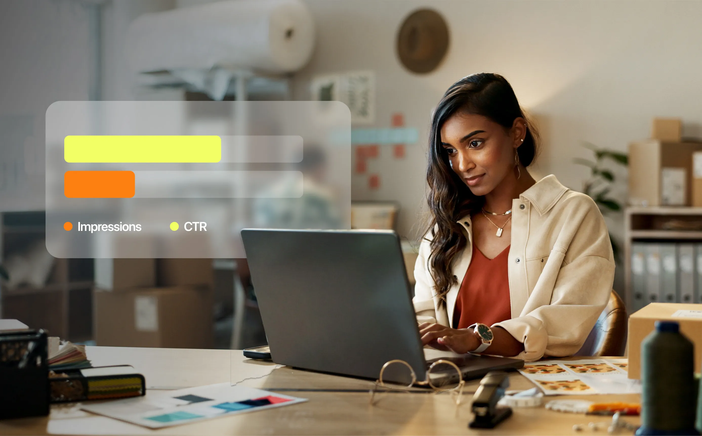Woman in an office working on a MacBook with a digital overlay showing impressions and CTR marketing metrics.